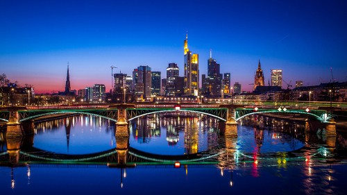 Image bridge over water near city buildings during night time