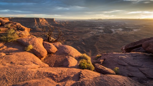 Image brown rock formation near green grass field during daytime