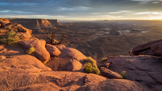 Image brown rock formation near green grass field during daytime