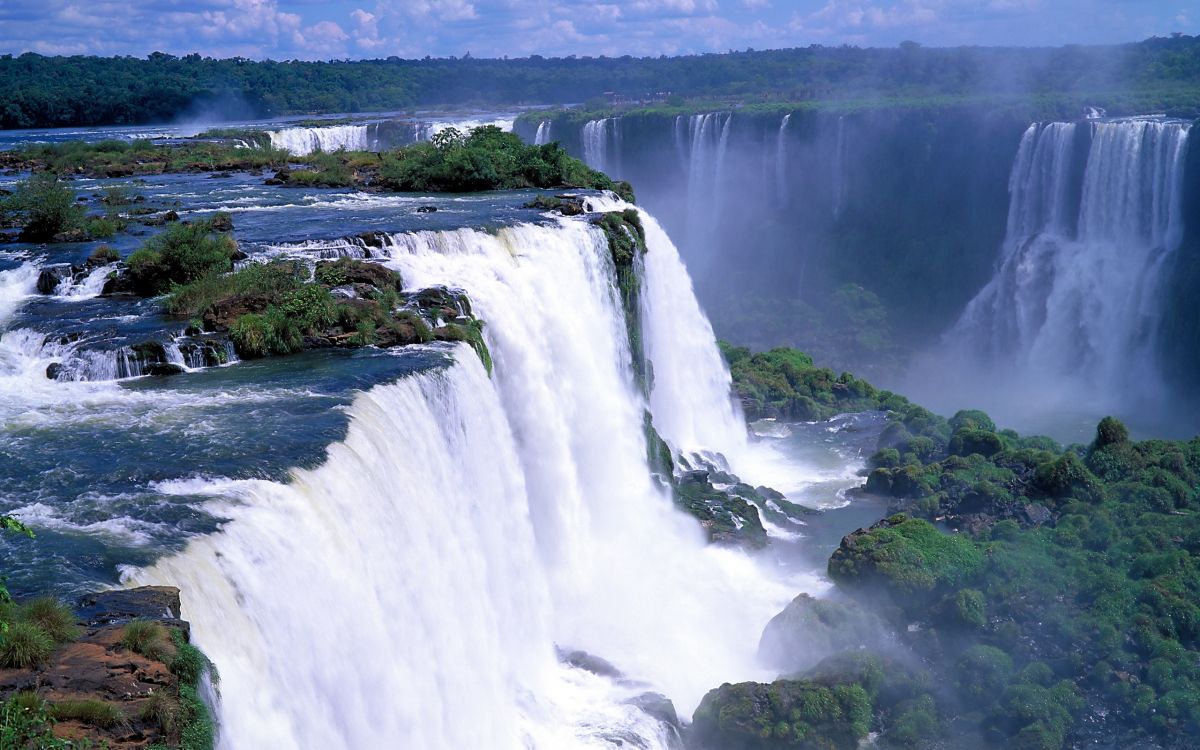 waterfalls on green grass field during daytime