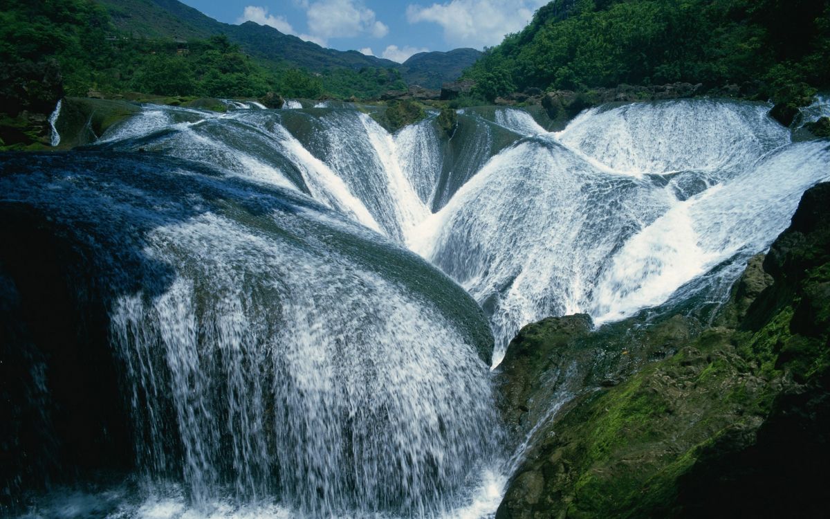 water falls on green mountain