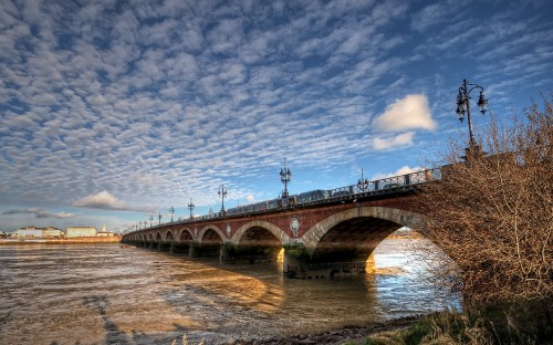 Image brown concrete bridge over river under blue sky during daytime