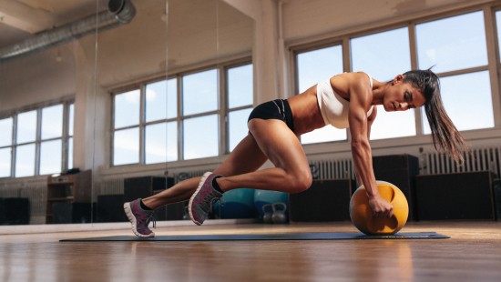 Image woman in black sports bra and black shorts doing push up