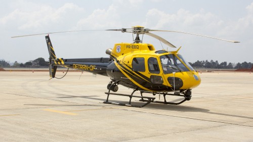 Image yellow and black helicopter on white sand during daytime