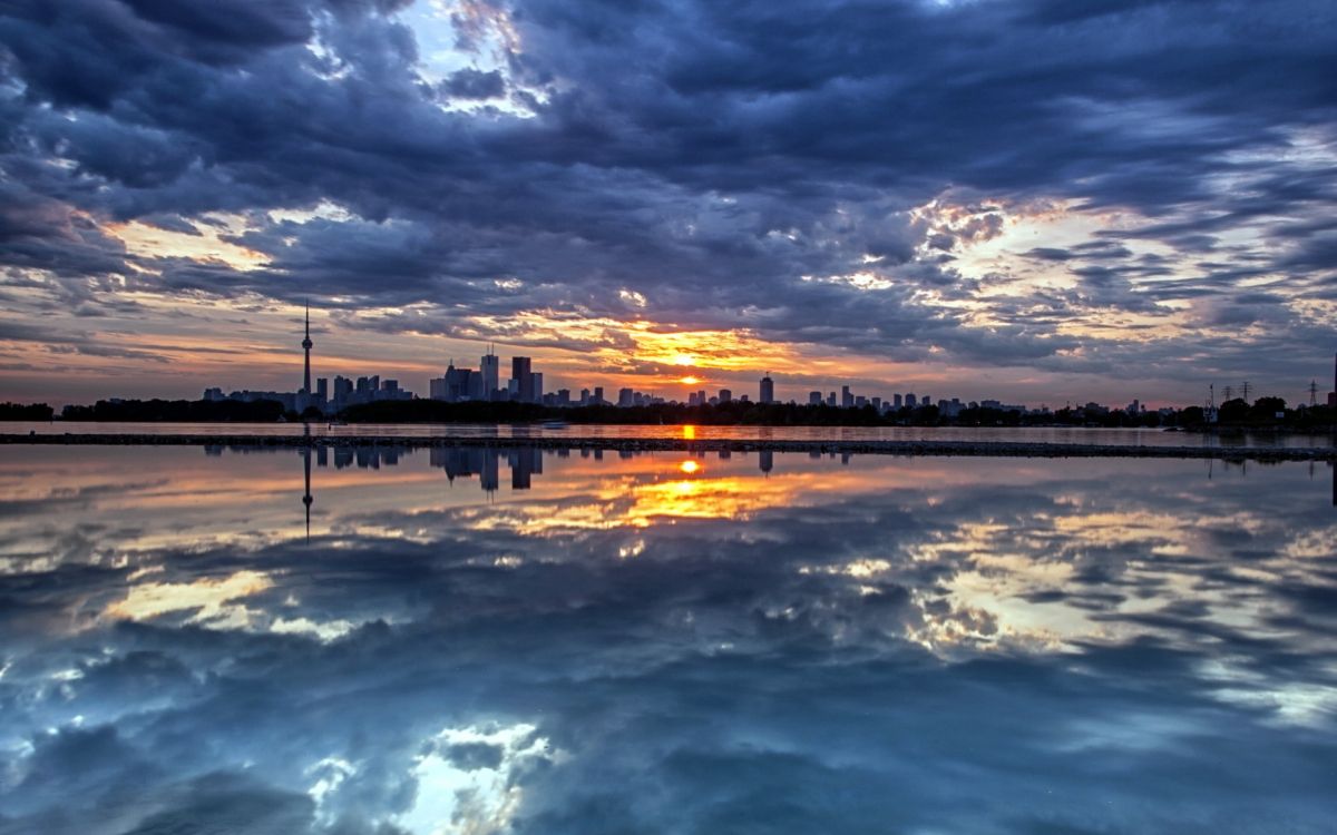 body of water under cloudy sky during sunset