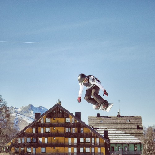 Image man in white jacket and black pants jumping on mid air during daytime