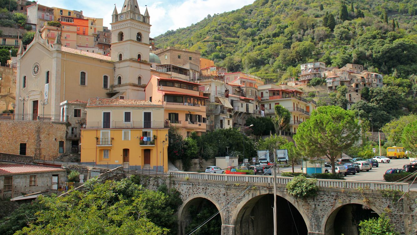 Bâtiment en Béton Brun Près Des Arbres Verts Pendant la Journée. Wallpaper in 2560x1440 Resolution