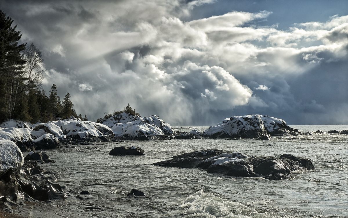 snow covered mountain under white clouds during daytime