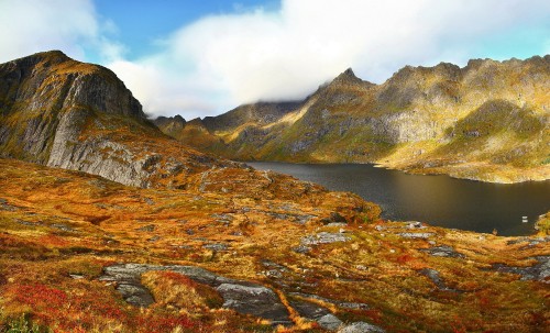 Image brown and green mountain beside lake under blue sky during daytime