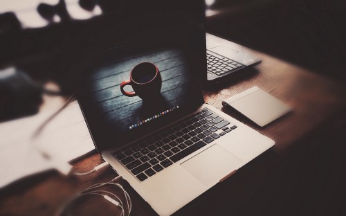 Image macbook pro on brown wooden table