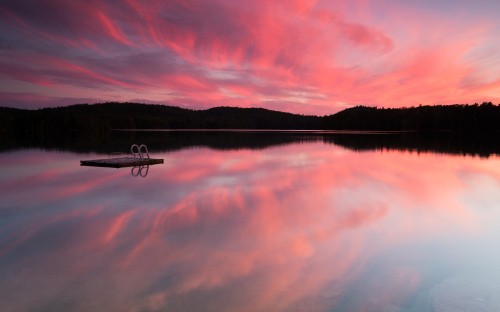 Image boat on calm water near mountain during sunset