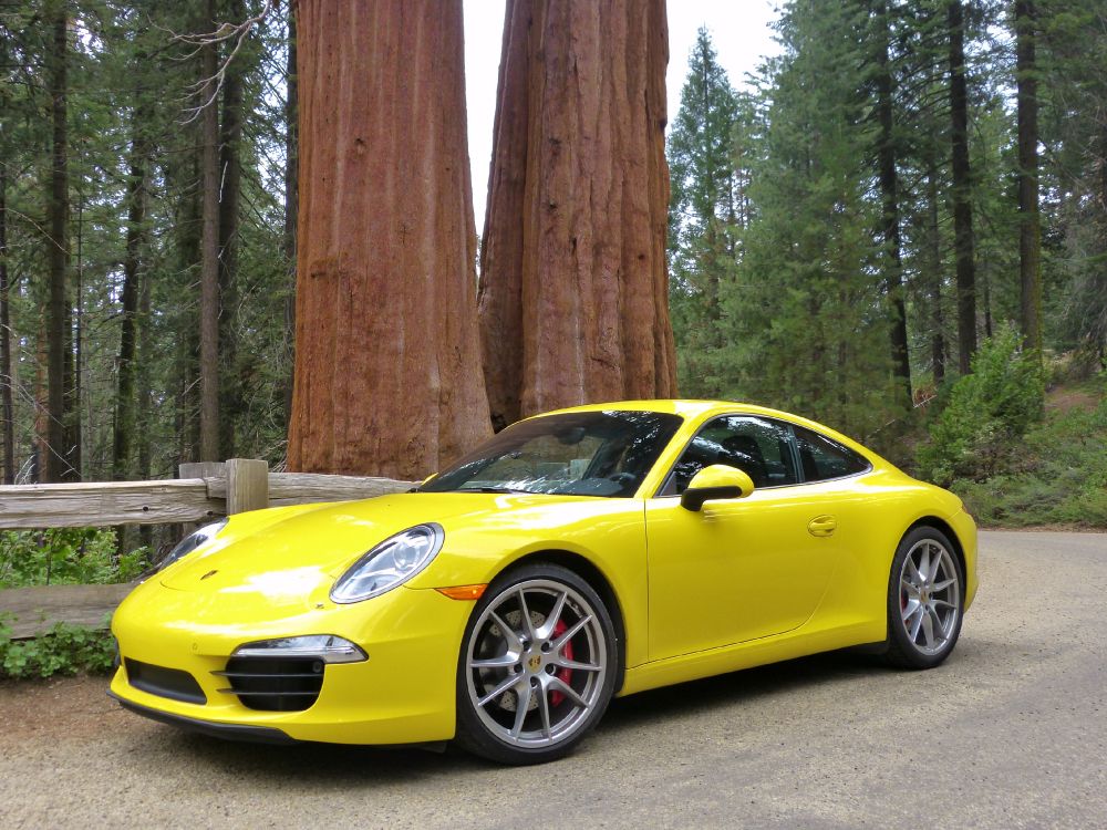Gelber Porsche 911 in Der Nähe Von Braunem Holzpfosten Geparkt. Wallpaper in 3264x2446 Resolution