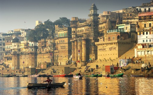 Image people riding on boat near brown concrete building during daytime