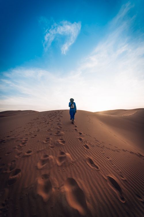 Personne en Veste Bleue Marchant Sur du Sable Brun Sous Ciel Bleu Pendant la Journée. Wallpaper in 3789x5683 Resolution