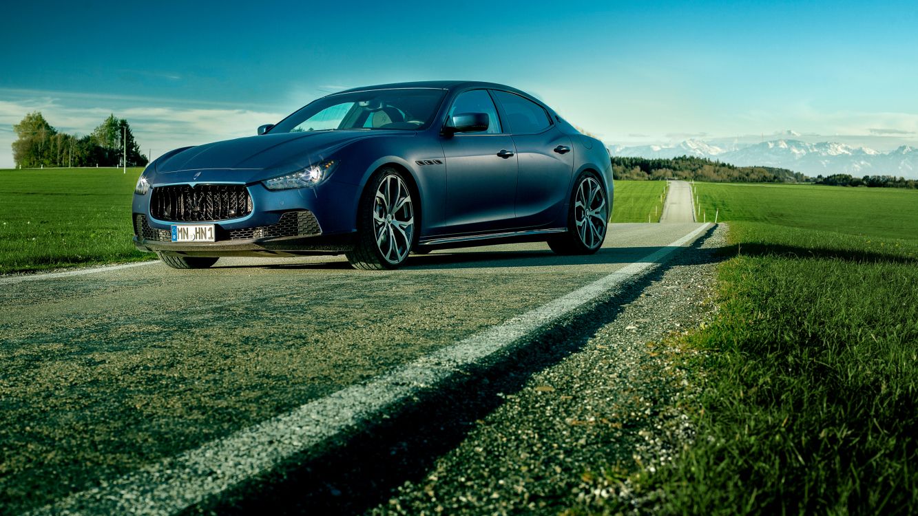 blue sedan on gray asphalt road during daytime