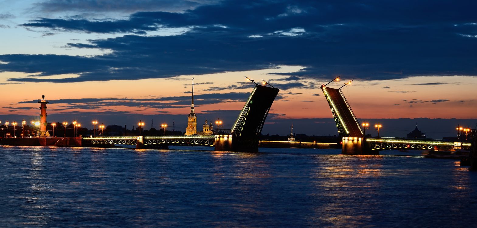 city skyline across body of water during sunset