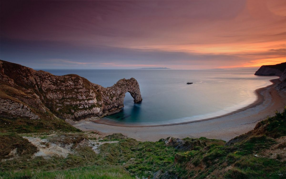 brown rock formation on body of water during daytime