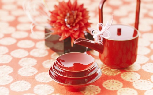 Image red ceramic mug on red and white floral table cloth