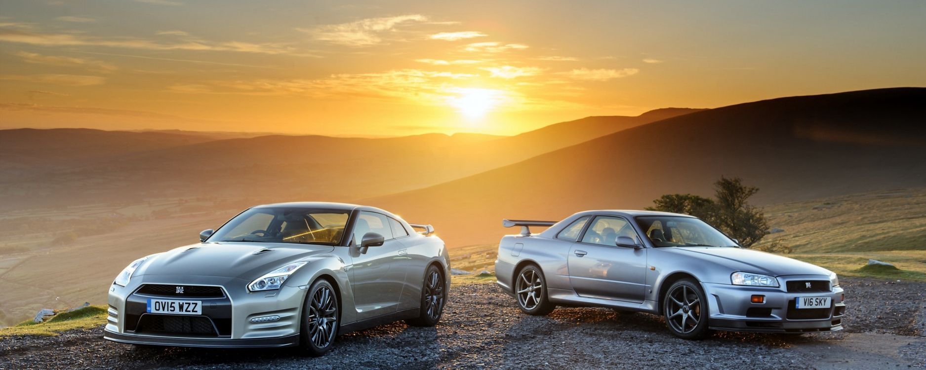 Porsche 911 Argent Sur Sable Noir Pendant le Coucher du Soleil. Wallpaper in 2560x1024 Resolution