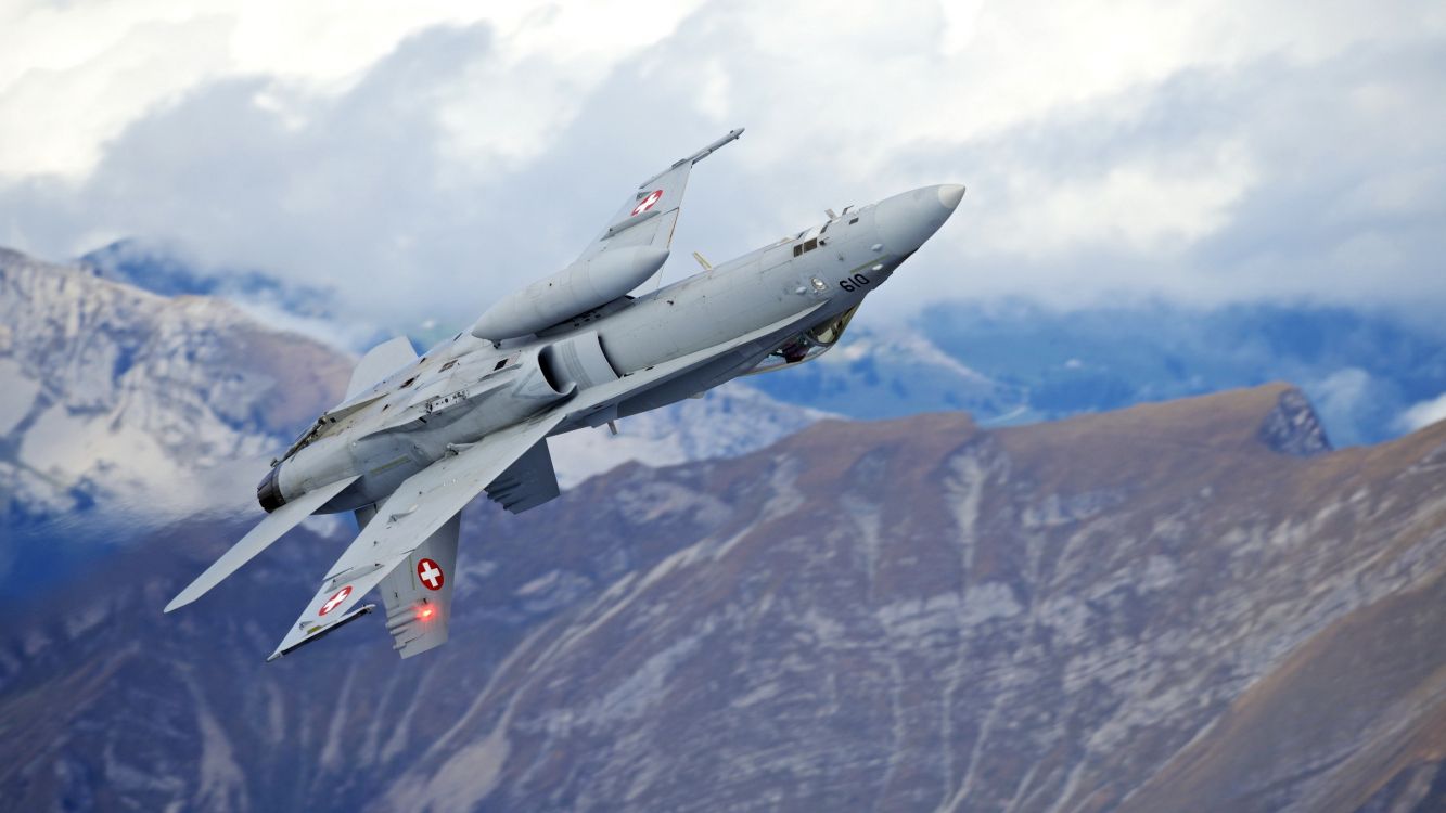 gray fighter jet flying over the mountain during daytime