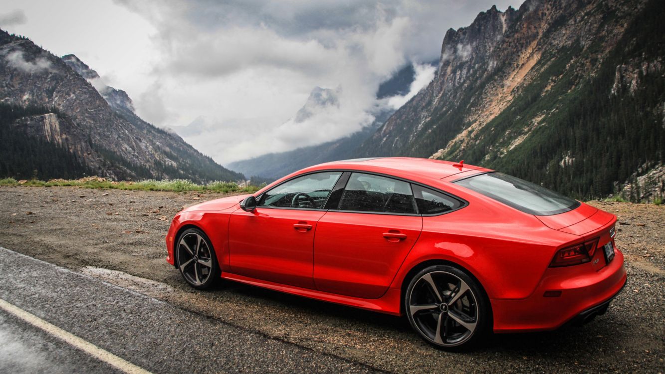 Rote Limousine Auf Schwarzem Boden in Der Nähe Von Grünem Grasfeld Tagsüber. Wallpaper in 2560x1440 Resolution