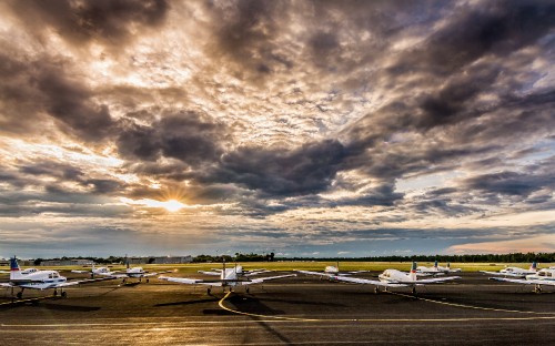 Image white and black plane on gray asphalt road under gray cloudy sky during daytime