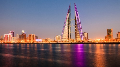 Image city skyline across body of water during night time