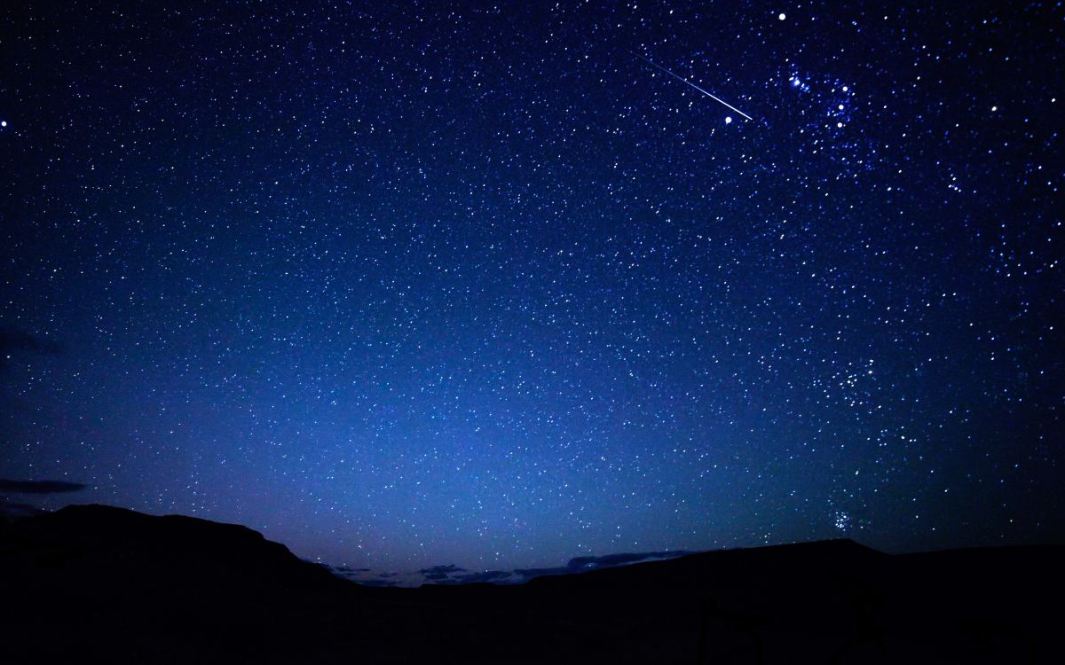 silhouette of mountain under blue sky during night time