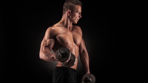 Image topless man holding black dumbbell