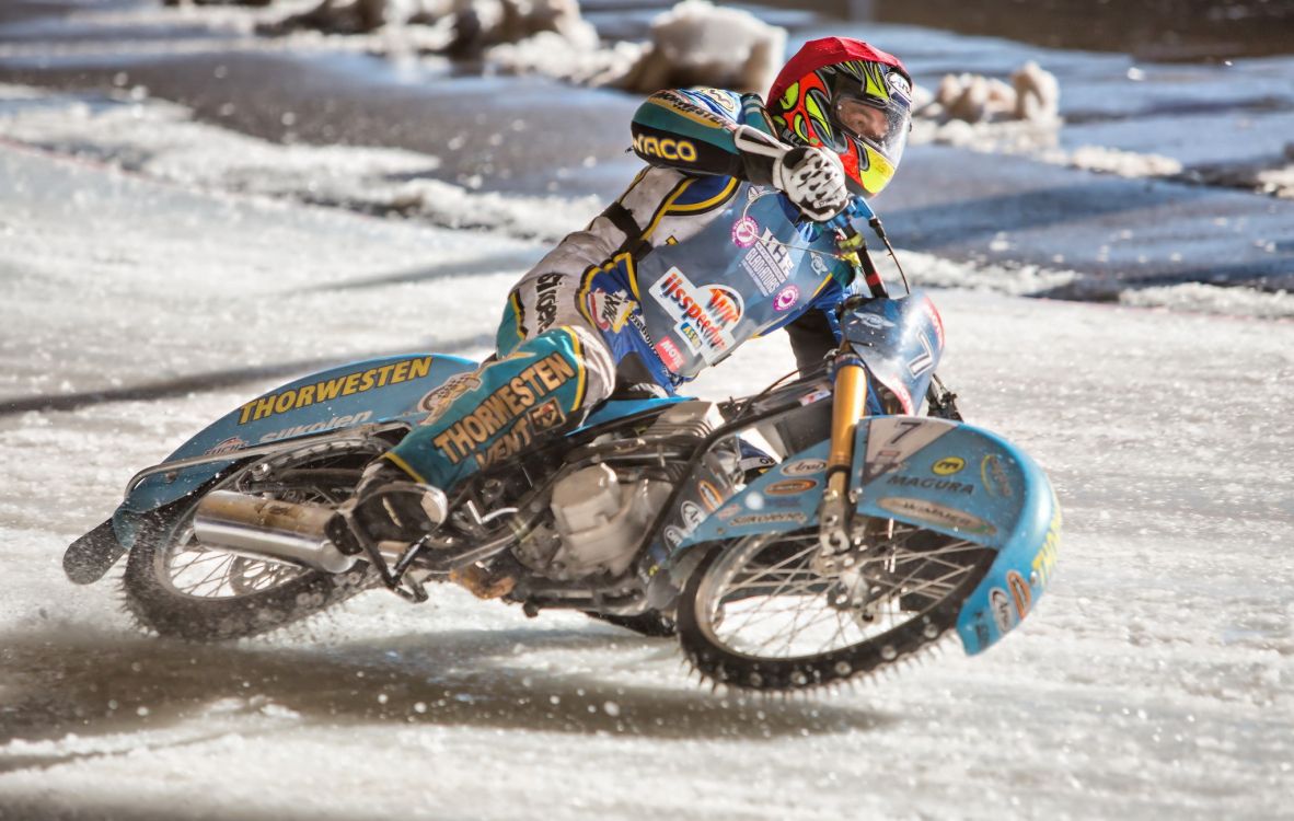 man riding blue and red motocross dirt bike