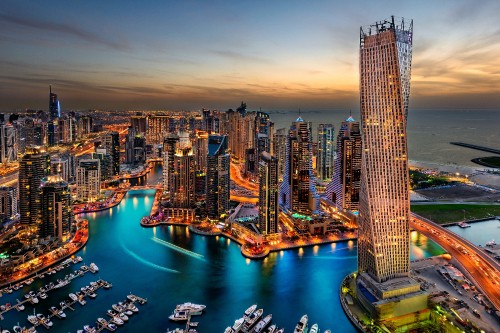 Image high rise buildings near body of water during night time