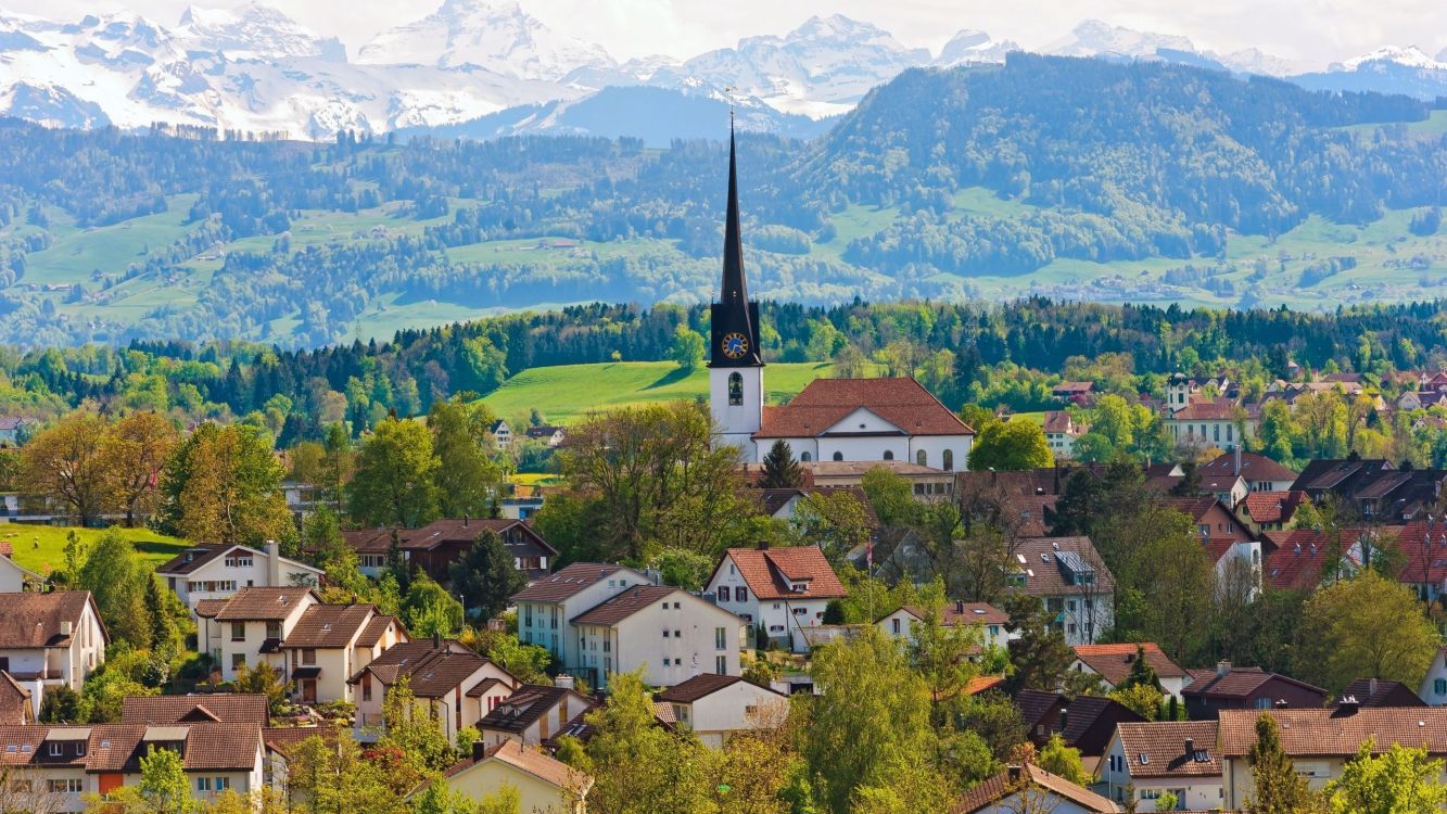 Weißes Und Braunes Betonhaus in Der Nähe Von Grünen Bäumen Und Bergen Tagsüber. Wallpaper in 2560x1440 Resolution