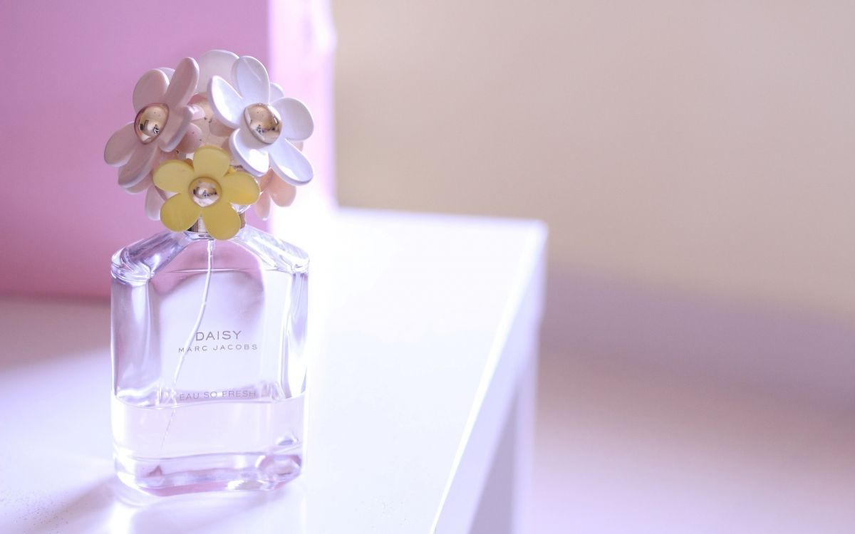 clear glass perfume bottle on white table