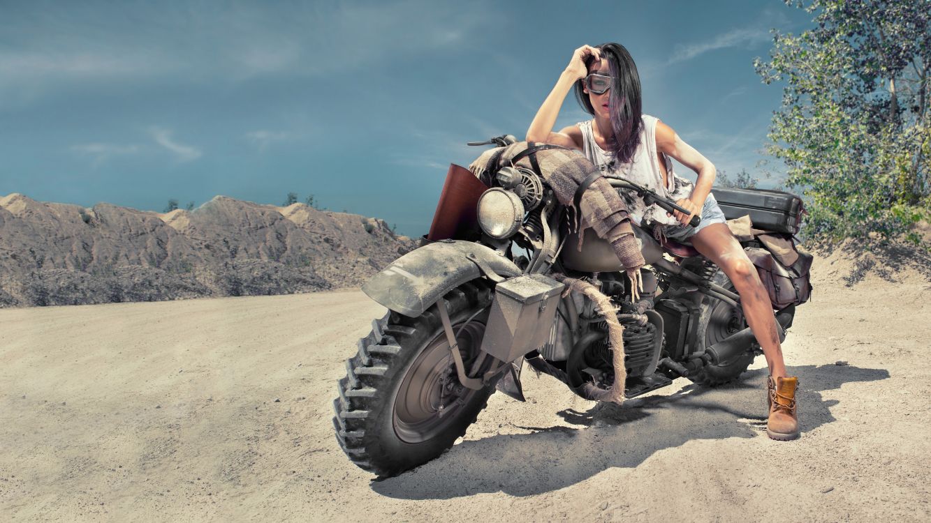 woman in black and gray camouflage tank top and black pants sitting on red motorcycle during