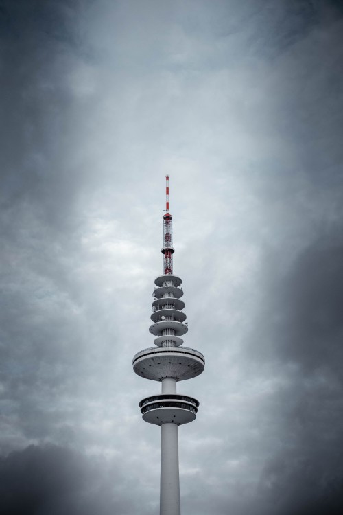 Image white and black tower under cloudy sky