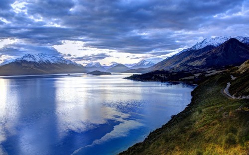 Image lake in the middle of mountains under white clouds and blue sky