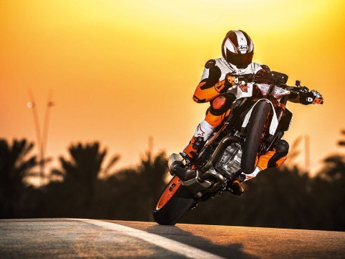 Image man in orange and black motorcycle suit riding on motorcycle