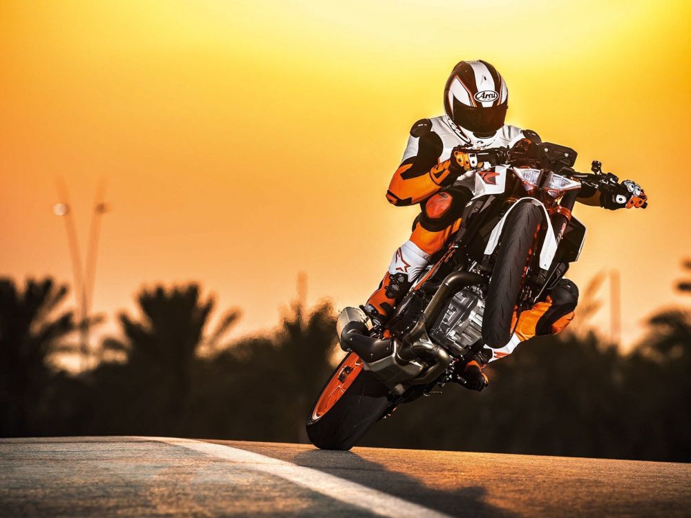 man in orange and black motorcycle suit riding on motorcycle