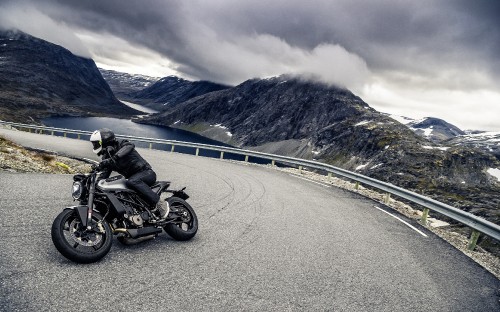 Image black motorcycle on road near mountain during daytime