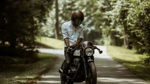 Image man in white shirt riding motorcycle on road during daytime