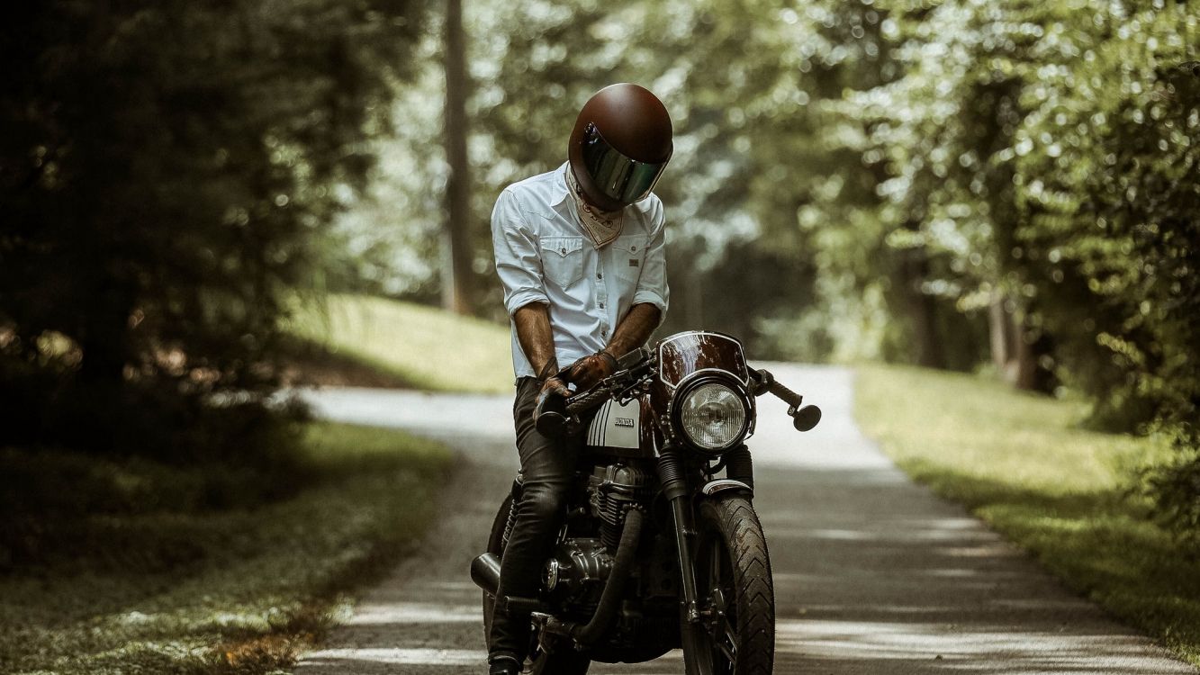 man in white shirt riding motorcycle on road during daytime