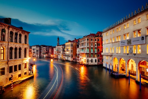 Image time lapse photography of cars on road between buildings during night time