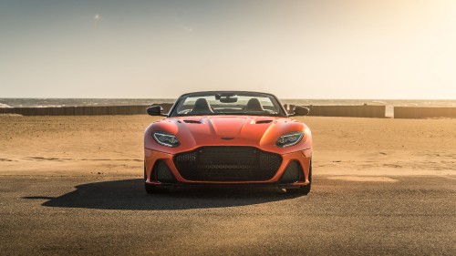 Image orange porsche 911 on brown dirt road during daytime