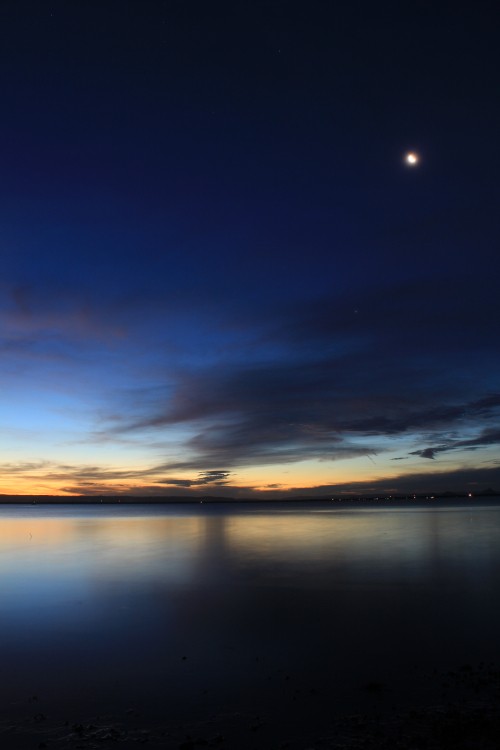 Image body of water under blue sky during sunset