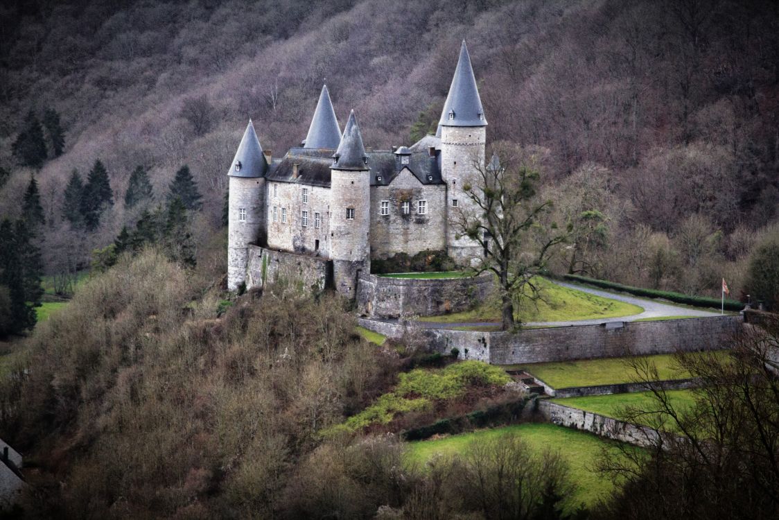 Castillo de Hormigón Gris en el Campo de Hierba Verde Cerca de la Montaña Durante el Día. Wallpaper in 2560x1707 Resolution