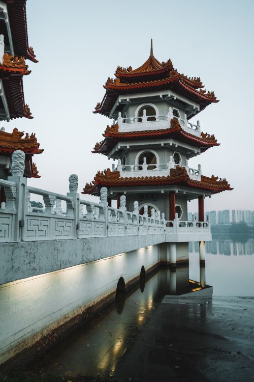 white and red concrete building near body of water during daytime