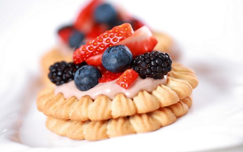 Image brown cupcake with blue and red berries on top