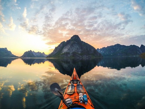 Image orange kayak on lake near mountain under white clouds during daytime