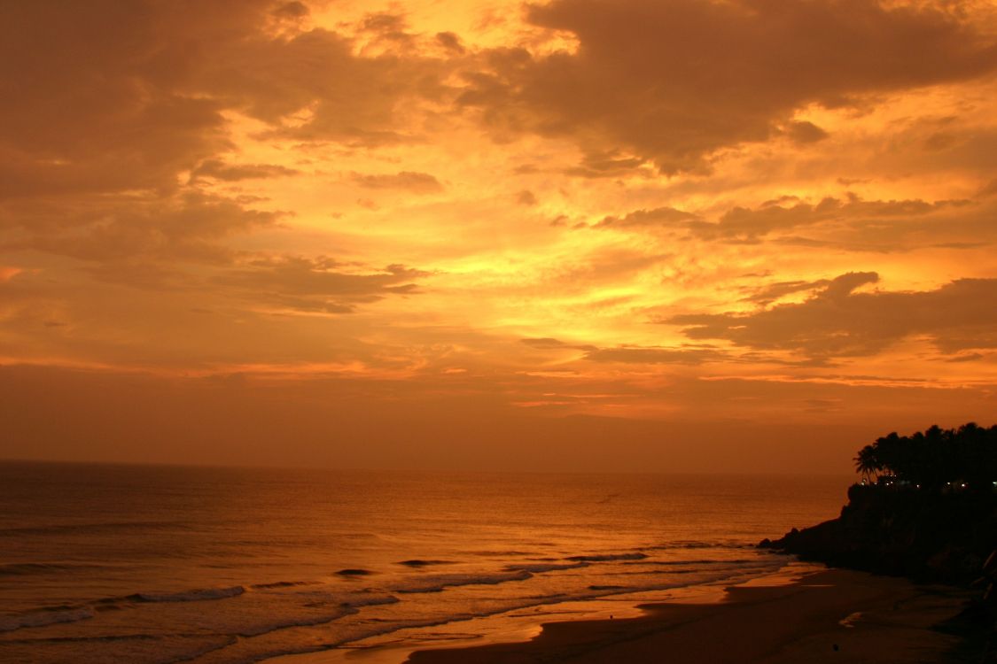 body of water under cloudy sky during sunset