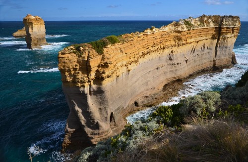 Image brown rock formation near body of water during daytime